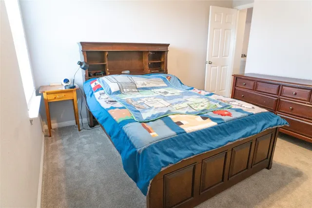 a bed sitting in a bedroom next to a window