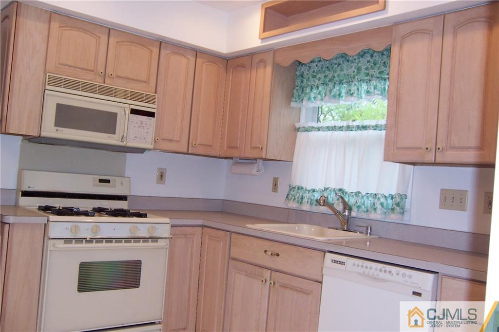 65 East Cliff Road Colonia, NJ 07067 - Photo 3 of 25 a kitchen with stainless steel appliances white cabinets and a stove top oven