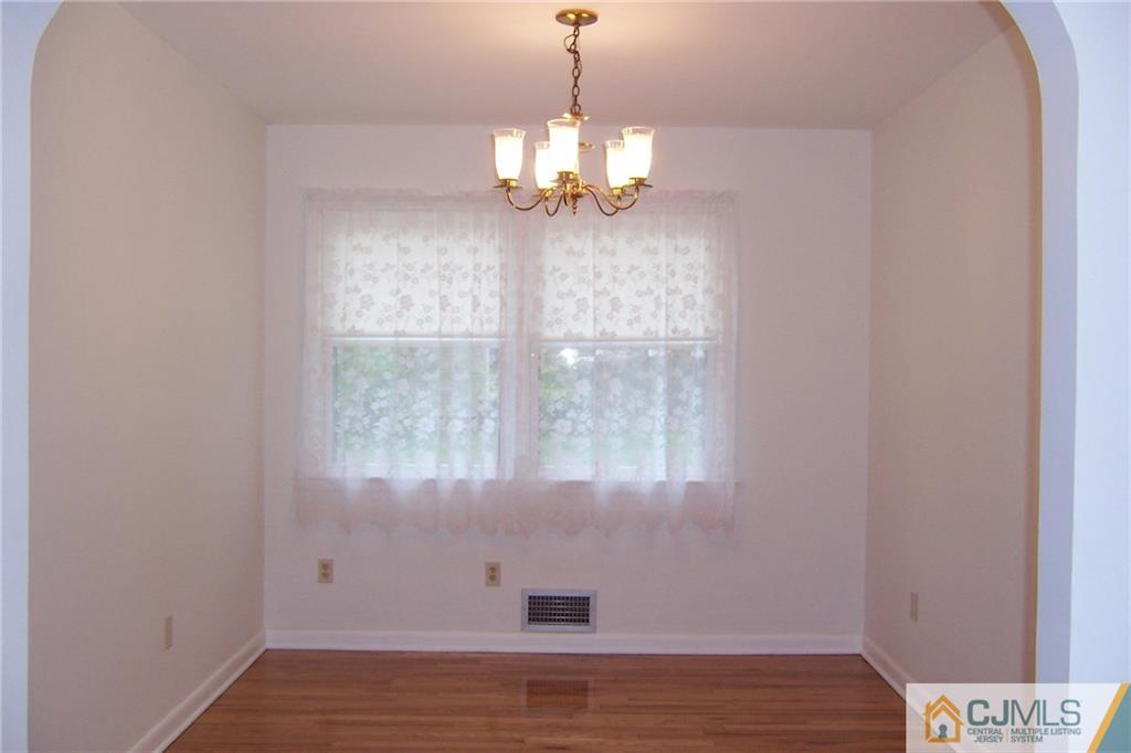 65 East Cliff Road Colonia, NJ 07067 - Photo 7 of 25 a view of an empty room with wooden floor and a window