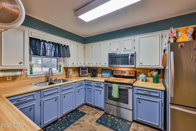 a kitchen area with stainless steel appliances kitchen island granite countertop a table and chairs in it