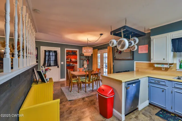 a dining room with stainless steel appliances granite countertop a dining table chairs and a refrigerator