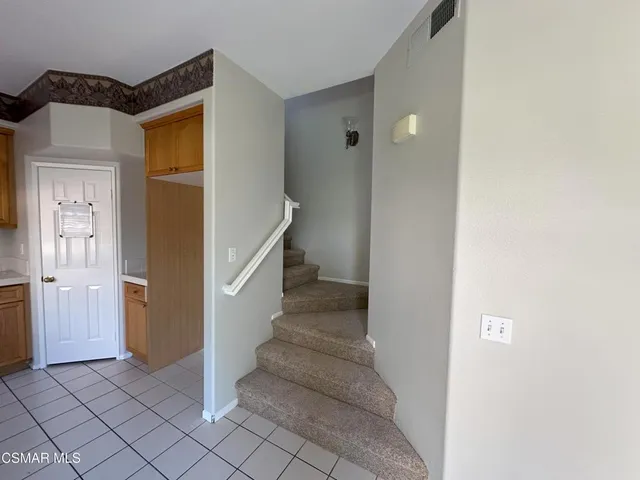 a view of a hallway with wooden cabinets and entryway