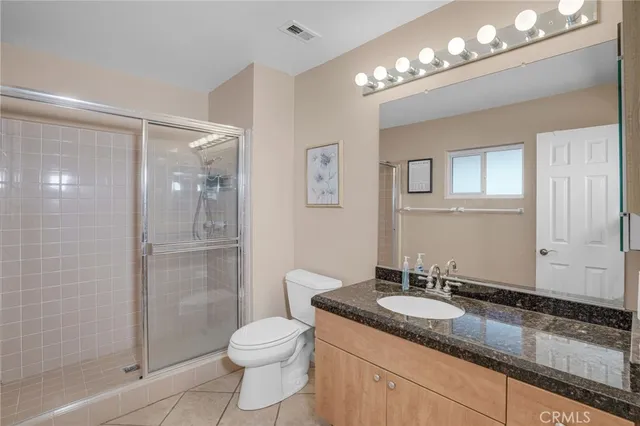 a bathroom with a granite countertop sink a toilet and shower