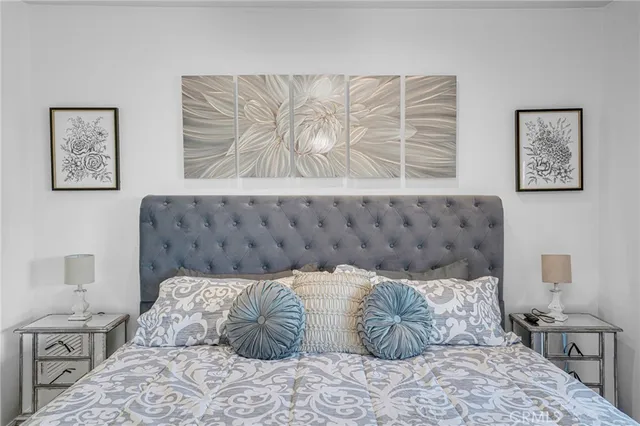 a large bed sitting in a bedroom next to a window with wooden floor