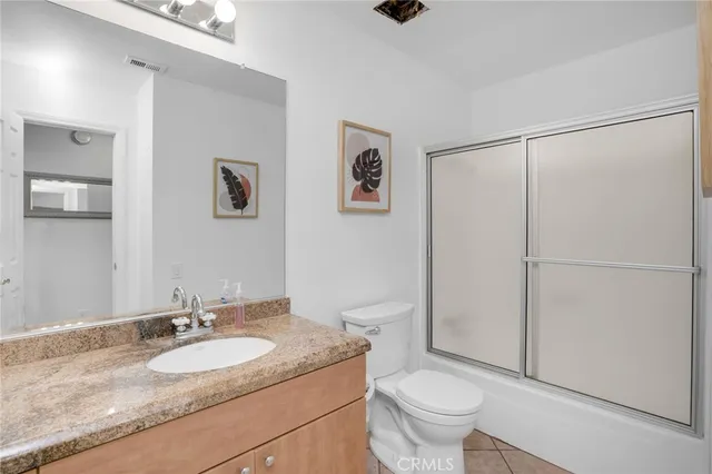 a bathroom with a granite countertop sink a toilet and a mirror