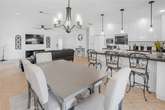 a view of a dining room with furniture a chandelier and wooden floor