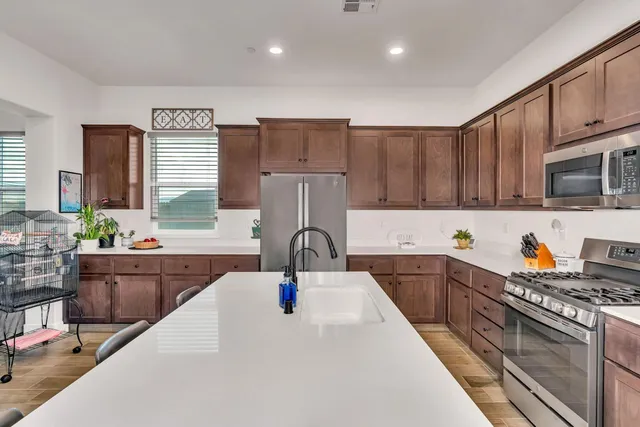a kitchen with kitchen island granite countertop a sink stove and cabinets