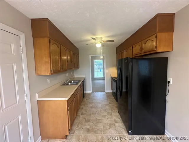 a kitchen with stainless steel appliances granite countertop a refrigerator and a sink