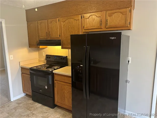 a kitchen with stainless steel appliances granite countertop a refrigerator and a stove