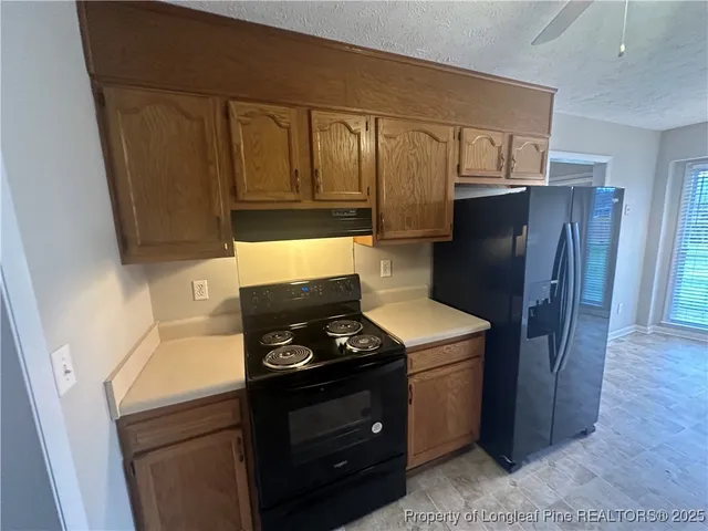 a kitchen with granite countertop cabinets and refrigerator