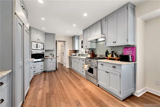a kitchen with white cabinets and appliances