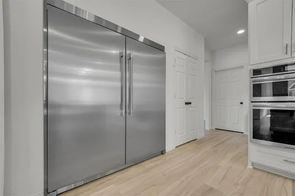a view of a kitchen with a refrigerator and a stove top oven