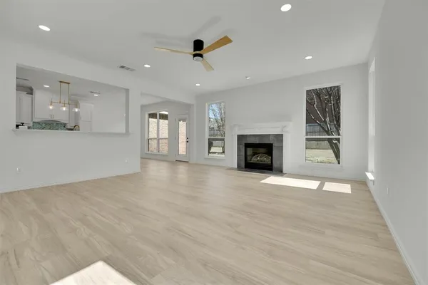 a view of an empty room with a fireplace and a window