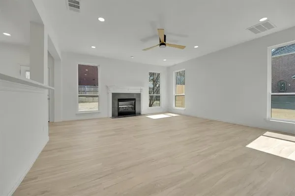 an empty room with windows and fireplace