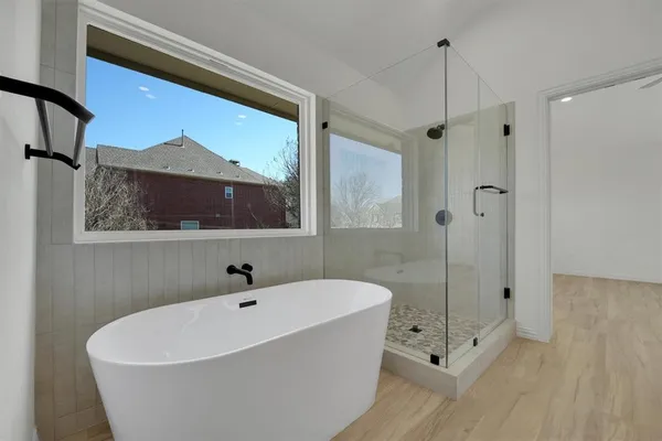 a white bath tub sitting next to a shower