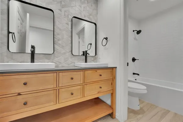 a bathroom with a granite countertop toilet sink and mirror