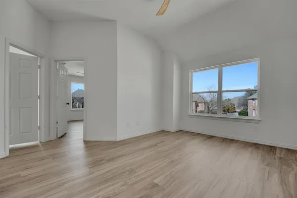 an empty room with wooden floor and a window