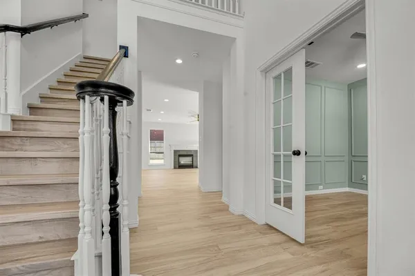 a view of hallway with wooden floor and stairs