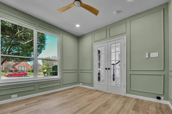 a view of empty room with wooden floor and windows