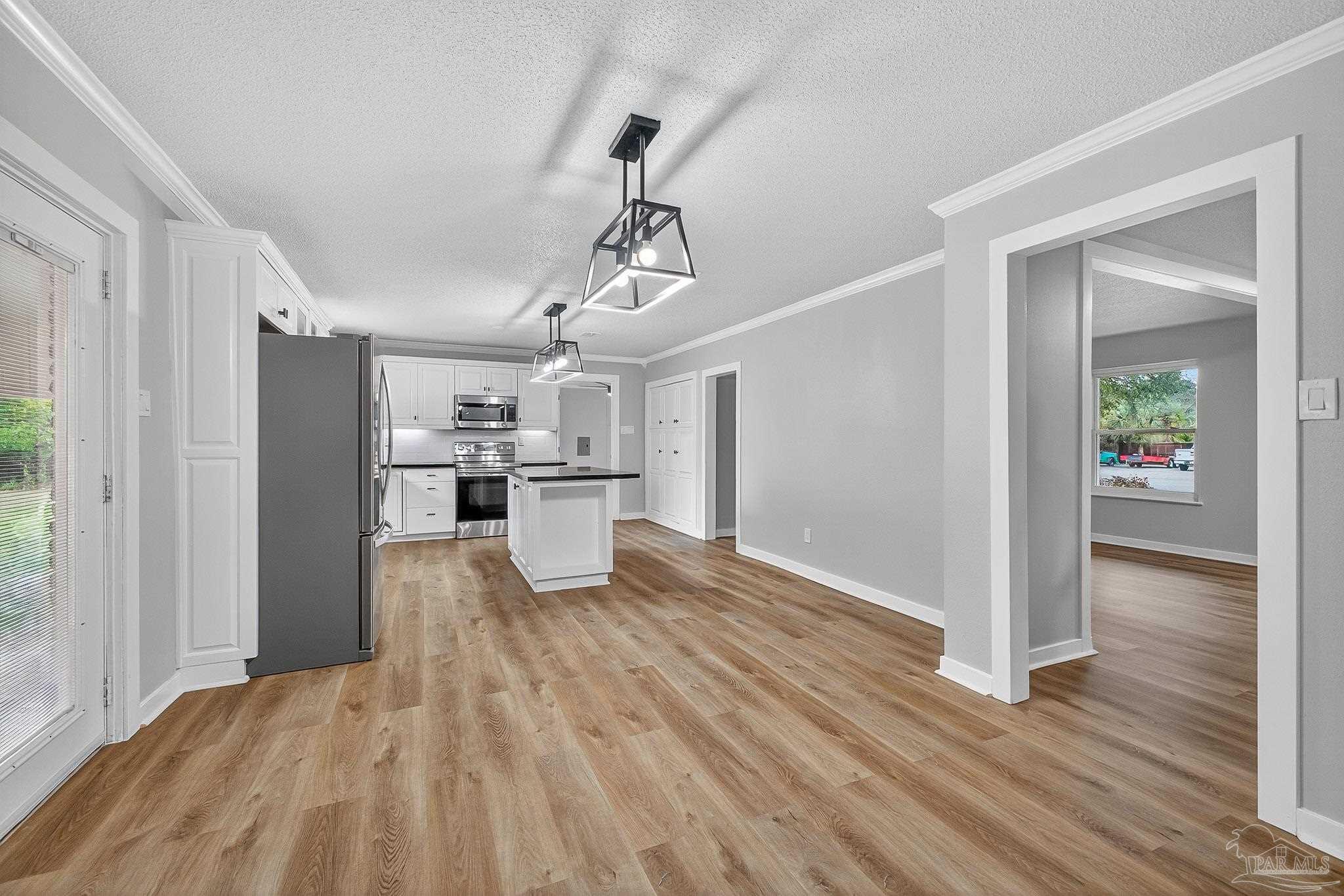 4673 Van Horn Road Milton, FL 32583 - Photo 13 of 53 a view of a kitchen with wooden floor and a refrigerator