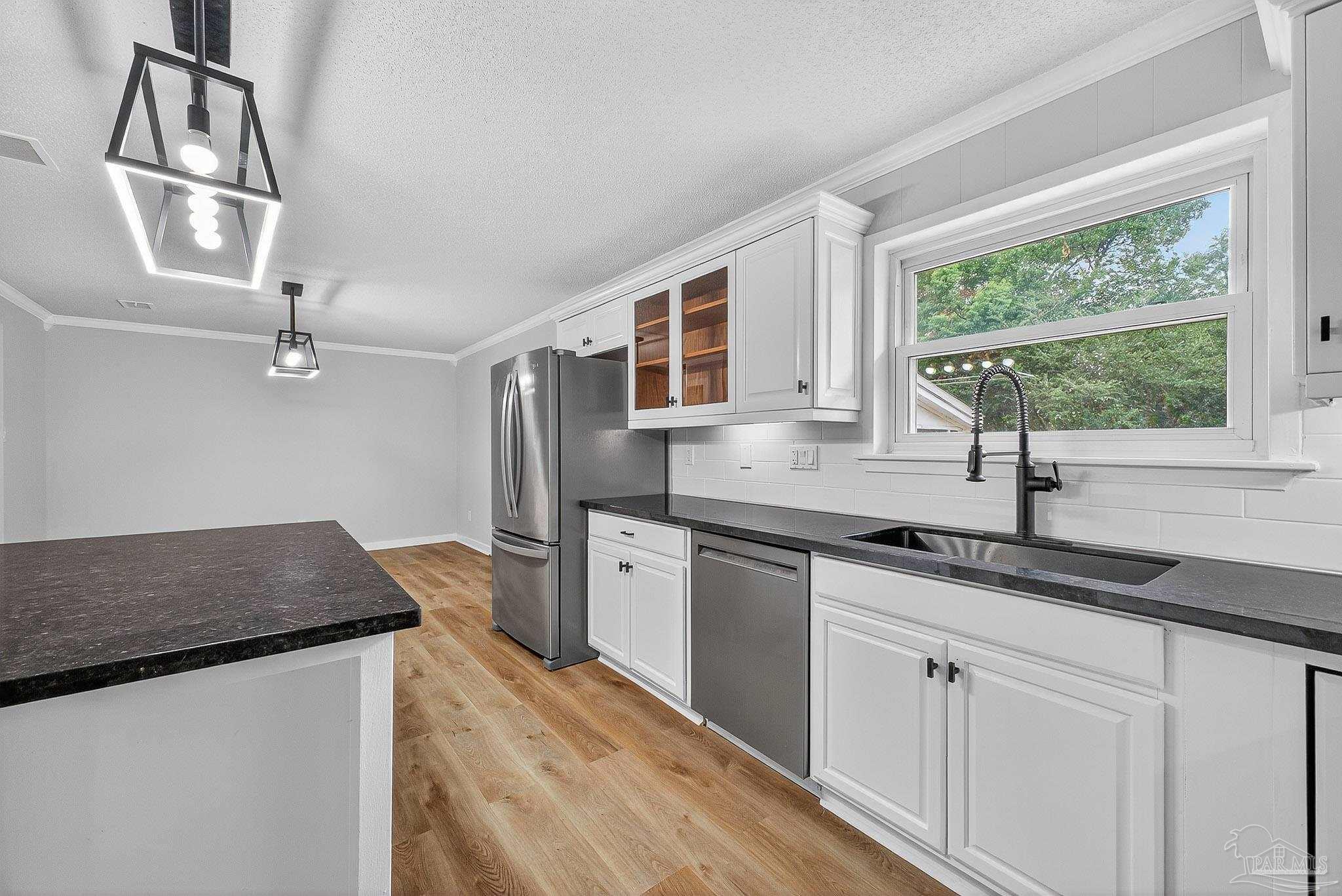 4673 Van Horn Road Milton, FL 32583 - Photo 21 of 53 a kitchen with stainless steel appliances granite countertop a sink stove and refrigerator