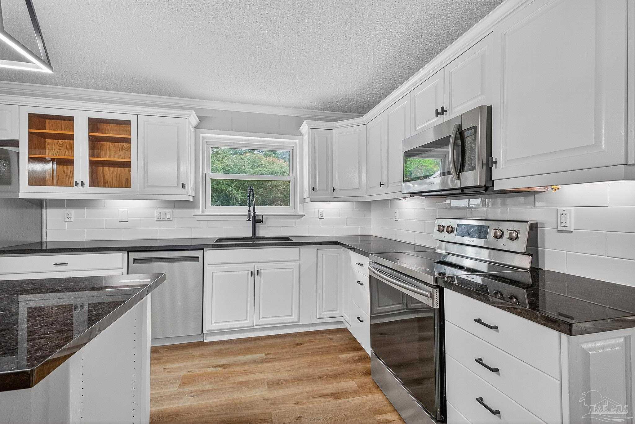 4673 Van Horn Road Milton, FL 32583 - Photo 23 of 53 a kitchen with stainless steel appliances granite countertop a sink stove and cabinets