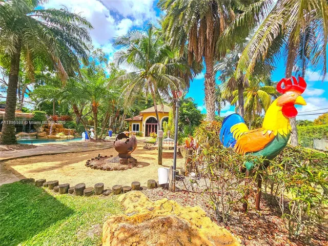 a front view of a house with a yard and potted plants