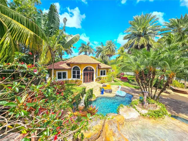 a living room with furniture a flat screen tv and a floor to ceiling window