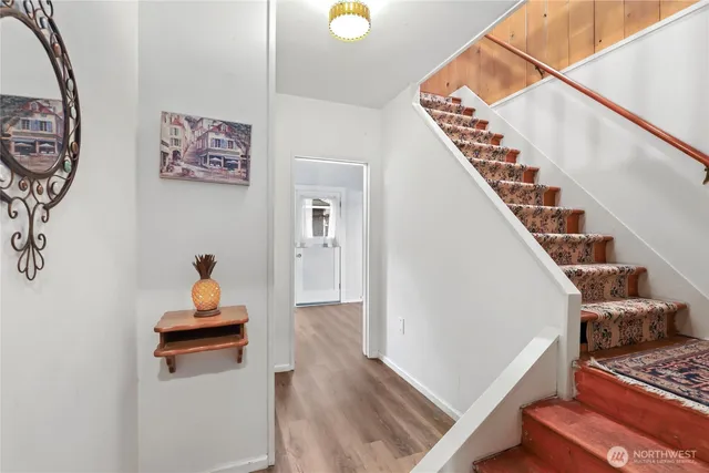 a view of a hallway with wooden floor and door