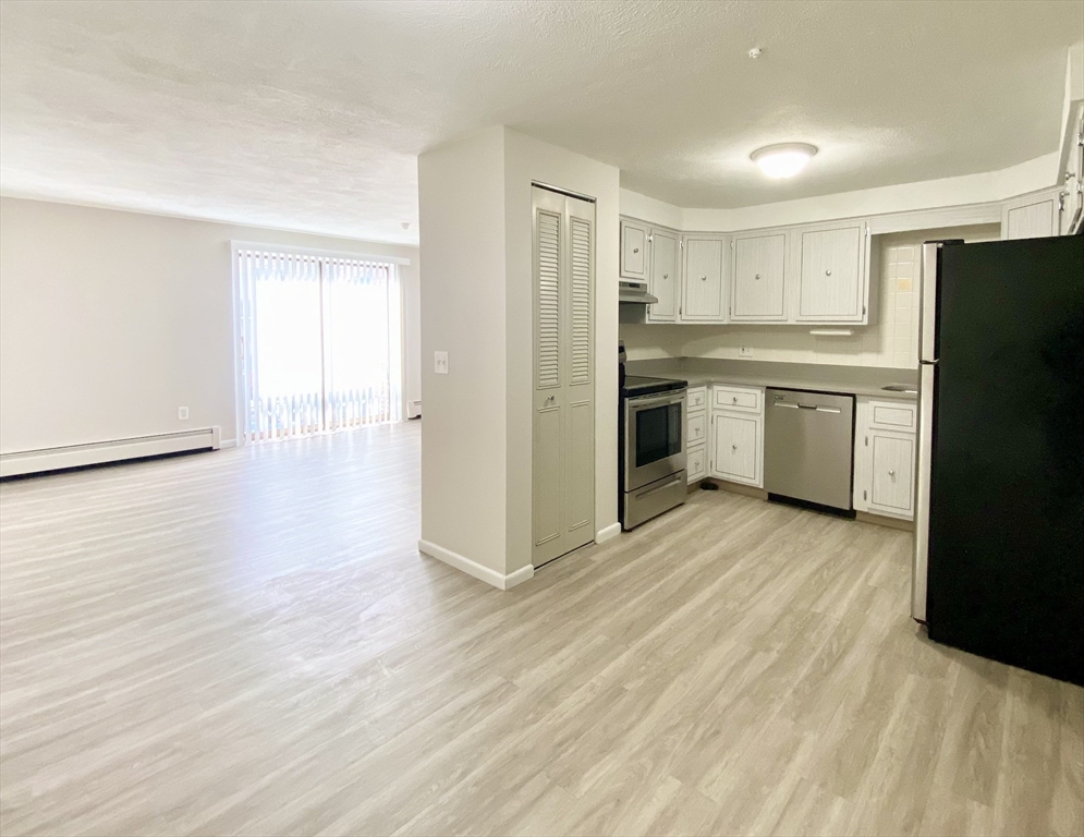 a kitchen with a refrigerator sink and cabinets