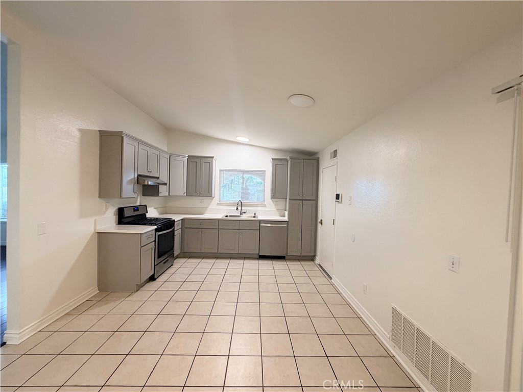 9668 Hemlock Street Rancho Cucamonga, CA 91730 - Photo 7 of 23 a kitchen with a sink a stove cabinets and a window