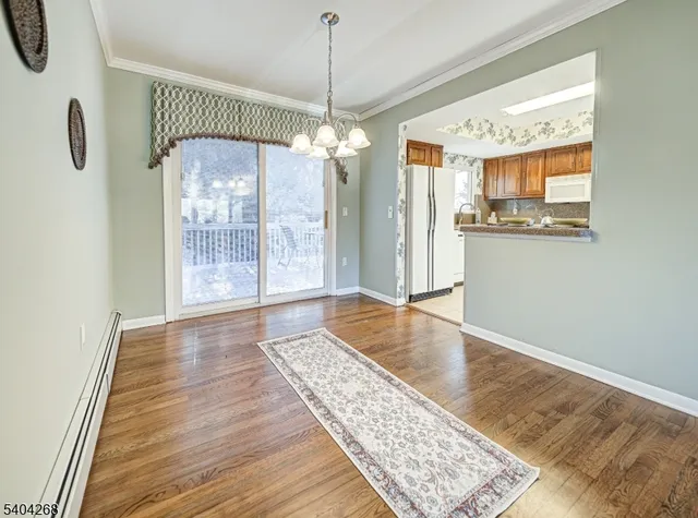 a view of an empty room with glass door and wooden floor