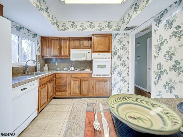 a large kitchen with a sink a stove a window and stainless steel appliances