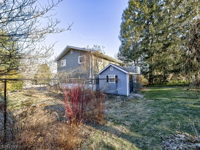 a brick house with a big yard and large trees