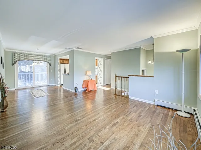 a view of empty room with wooden floor and window