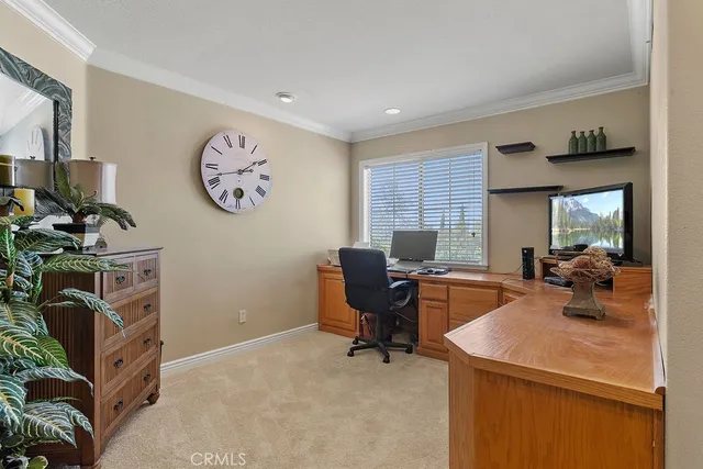 a view of a workspace with furniture and a window