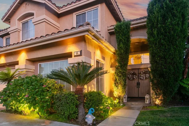 a yellow house with flower garden and a small yard