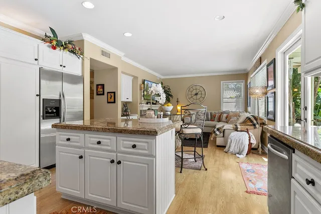 a living room with furniture kitchen view and large windows