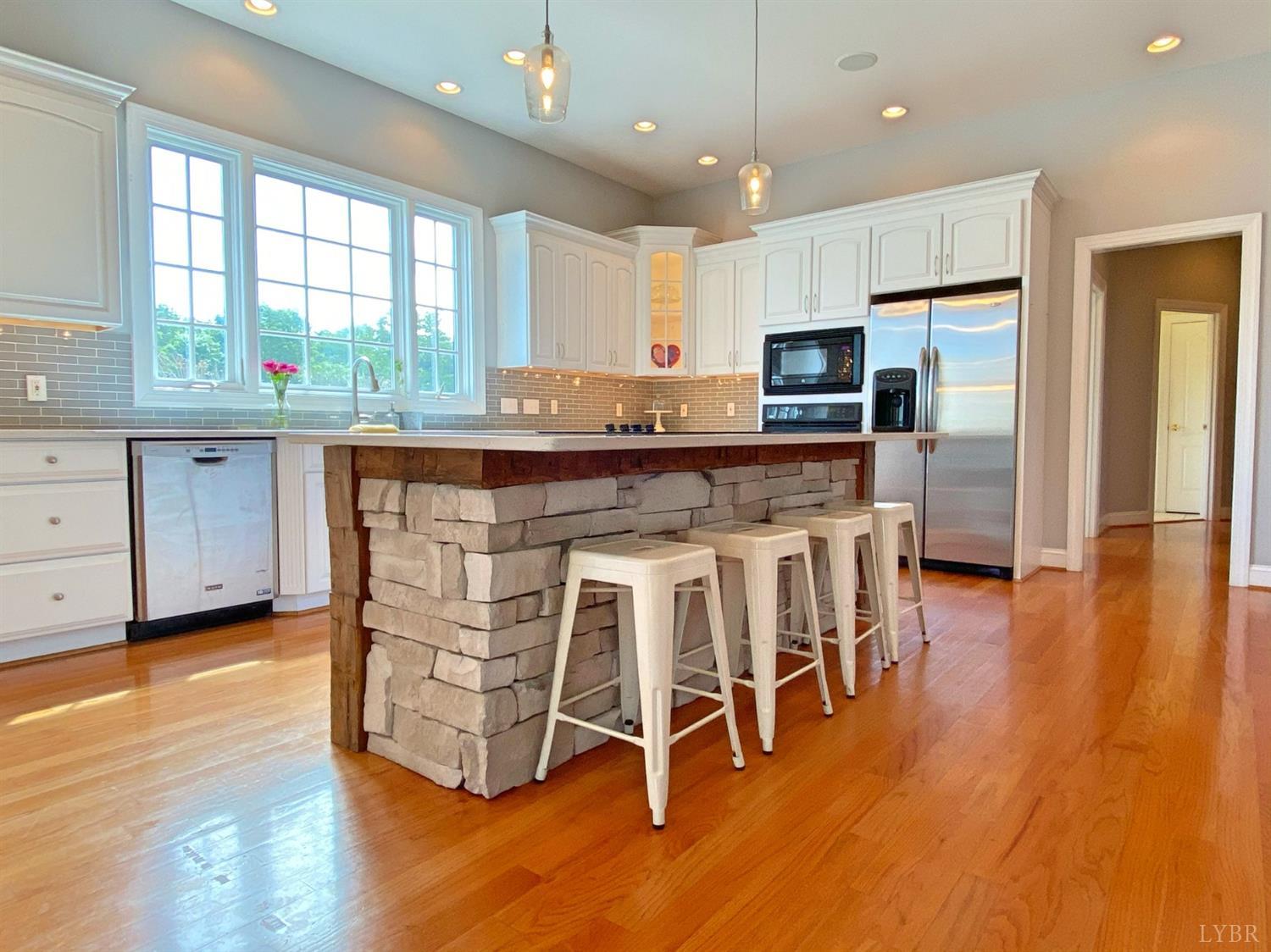 798 High Peak Road Monroe, VA 24574 - Photo 13 of 96 a kitchen with stainless steel appliances granite countertop a table chairs sink refrigerator and microwave