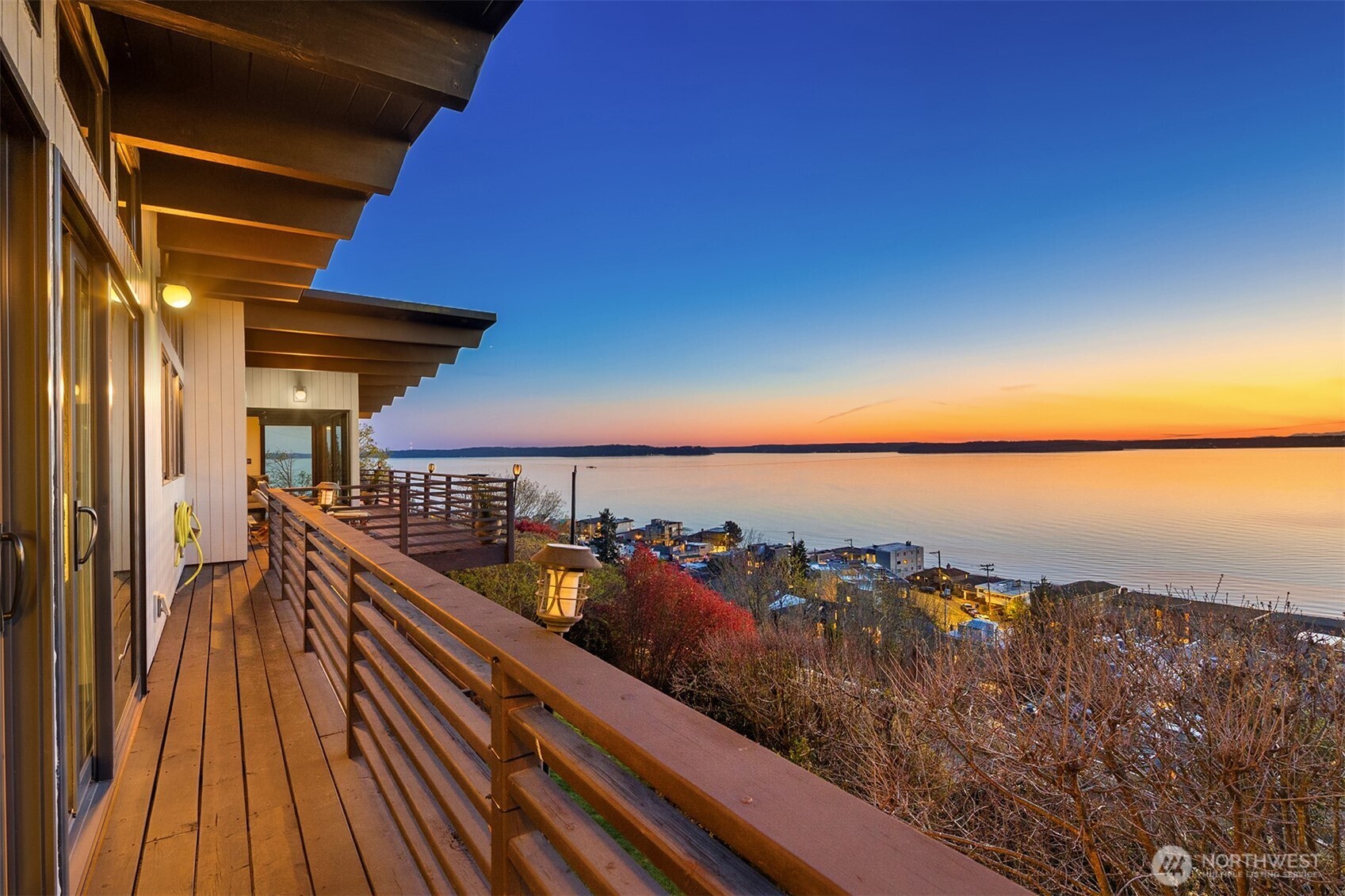 3831 58th Avenue Southwest Seattle, WA 98116 - Photo 23 of 40 a view of a balcony with wooden chairs and floor to ceiling window and outdoor kitchen