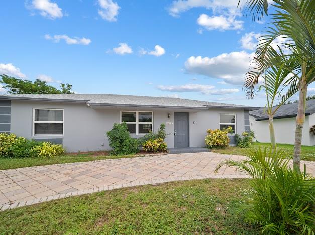 19426 Colorado Circle Boca Raton, FL 33434 - Photo 22 of 32 a front view of a house with a yard and potted plants