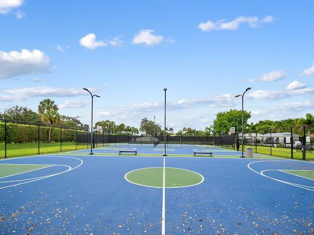 19426 Colorado Circle Boca Raton, FL 33434 - Photo 24 of 32 a view of a swimming pool with a yard and trees in the background