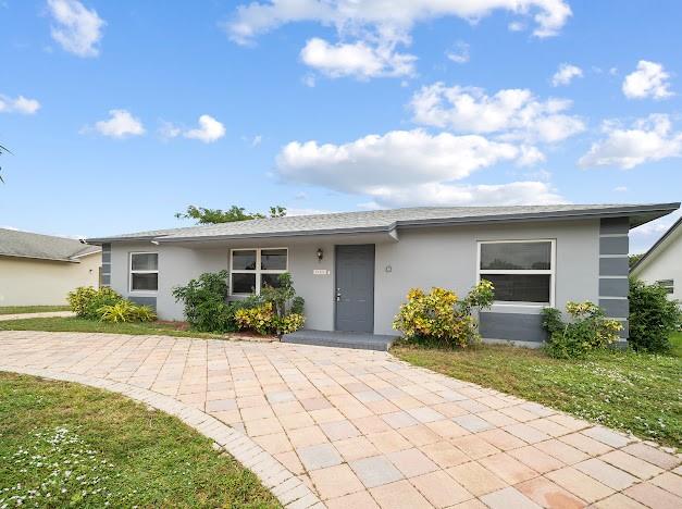 19426 Colorado Circle Boca Raton, FL 33434 - Photo 28 of 32 a front view of a house with a yard and potted plants