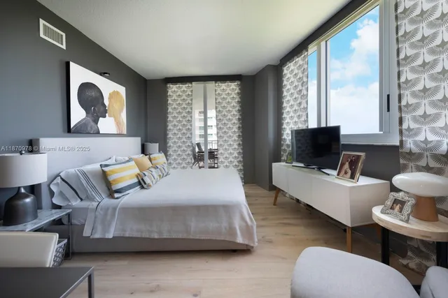 a bedroom with a large bed and a flat screen tv