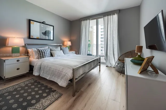 a spacious bedroom with a bed and a flat screen tv