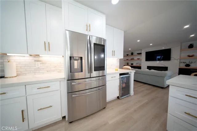 a kitchen with white cabinets and stainless steel appliances