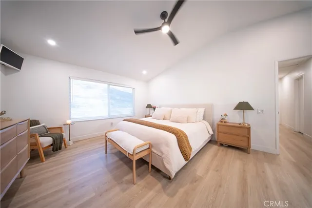 a bedroom with a bed couch and wooden floor