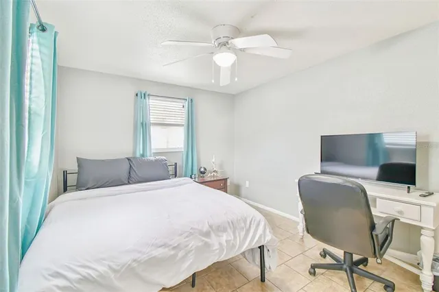 a bedroom with a bed a chair and a chandelier