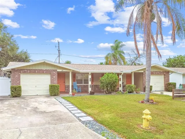 a front view of a house with a garden and plants