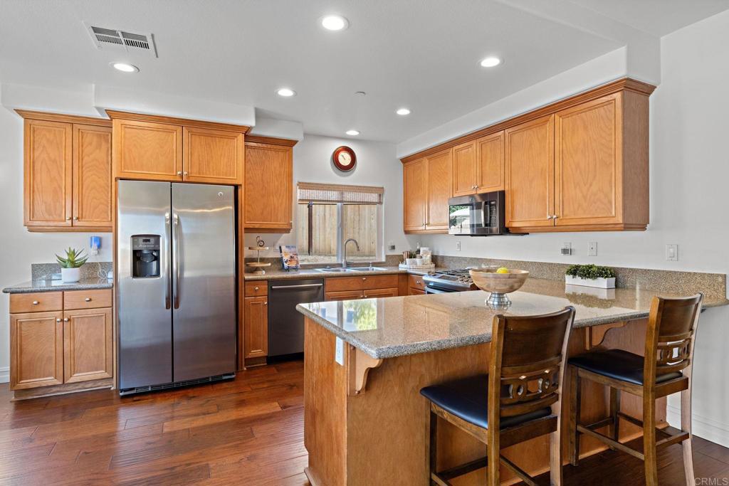 655 Dimaio Way Escondido, CA 92027 - Photo 13 of 46 a kitchen with granite countertop a stove a sink a refrigerator and a dining table